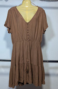 A brown short-sleeve dress with a V-neckline and button details, displayed on a mannequin torso against a white wall.