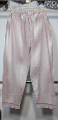 A pair of cropped pants with vertical red and white stripes, hanging on a clear plastic hanger against a white wall.