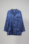 Blue patterned shirt on a hanger against a white wall