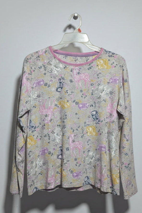 Floral-patterned long-sleeve shirt on a hanger against a white wall.