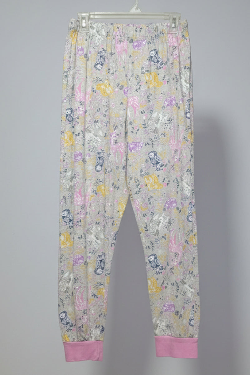 Floral-patterned pants hanging on a rack with other clothing items.