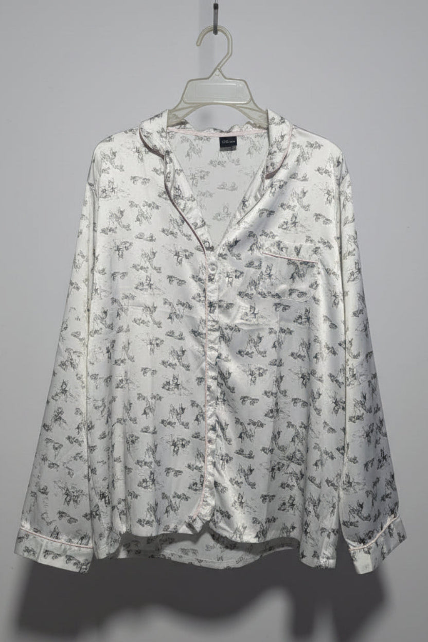 Floral-patterned blouse on a hanger against a gray background