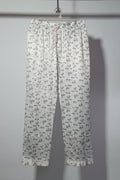 Floral-patterned pants hanging on a rack with other clothing items.