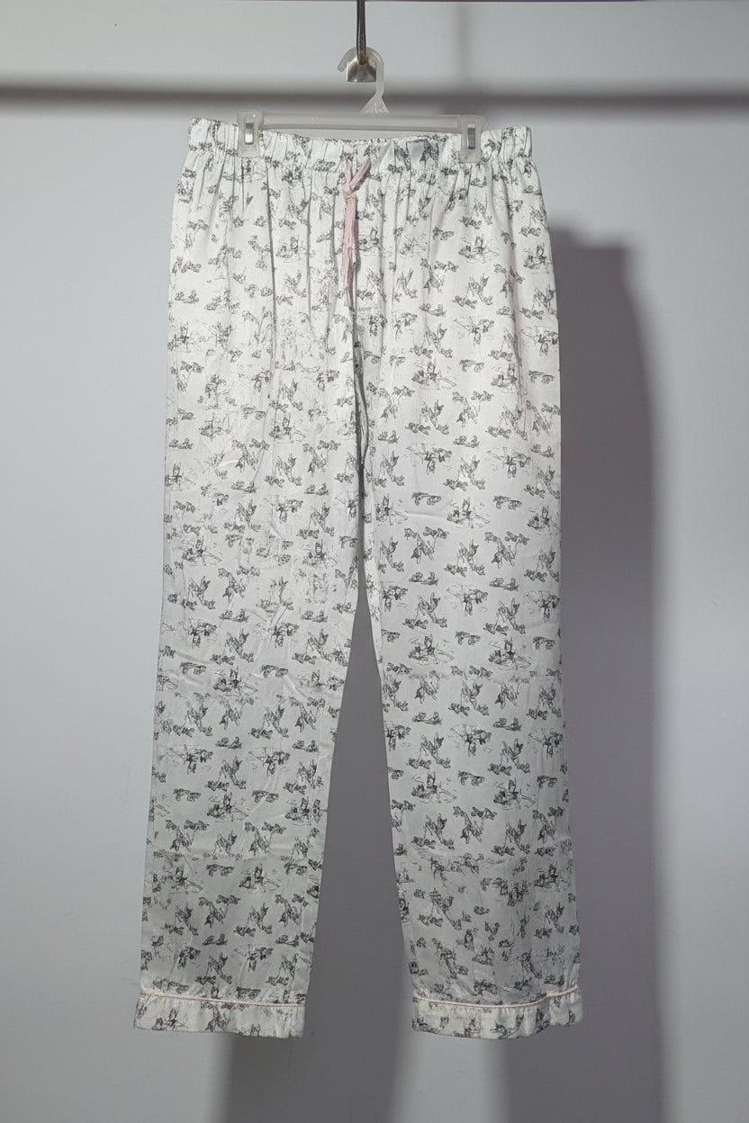 Floral-patterned pants hanging on a rack with other clothing items.