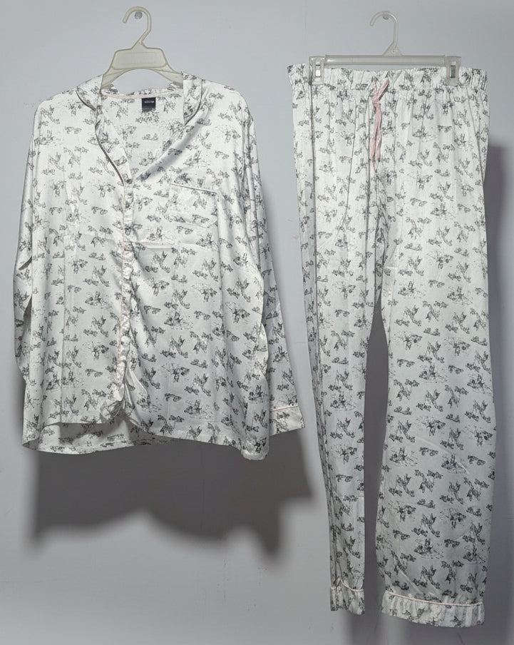 Floral-patterned shirt and pants hanging on a rack against a white wall.