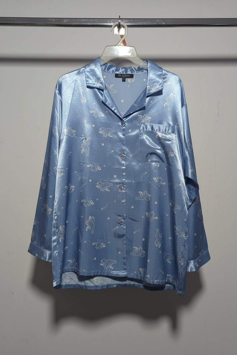 Blue satin pajama set on a rack with a white wall background