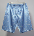 Blue satin pajama set hanging on a rack against a white wall.