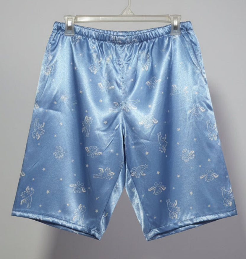 Blue satin pajama set hanging on a rack against a white wall.