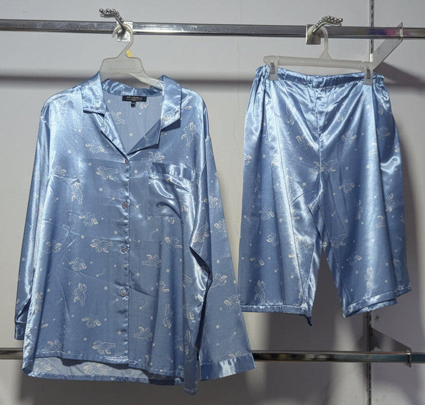 Blue satin pajama set on a rack with a white wall background