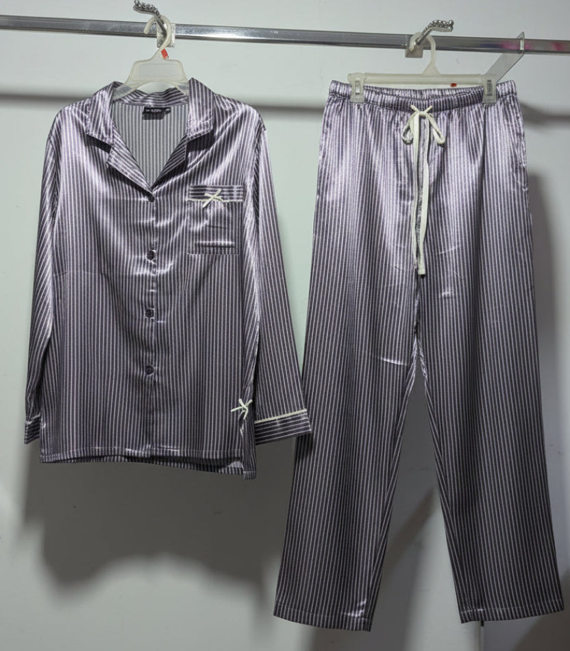 Striped pajama set hanging on a rack against a white wall.