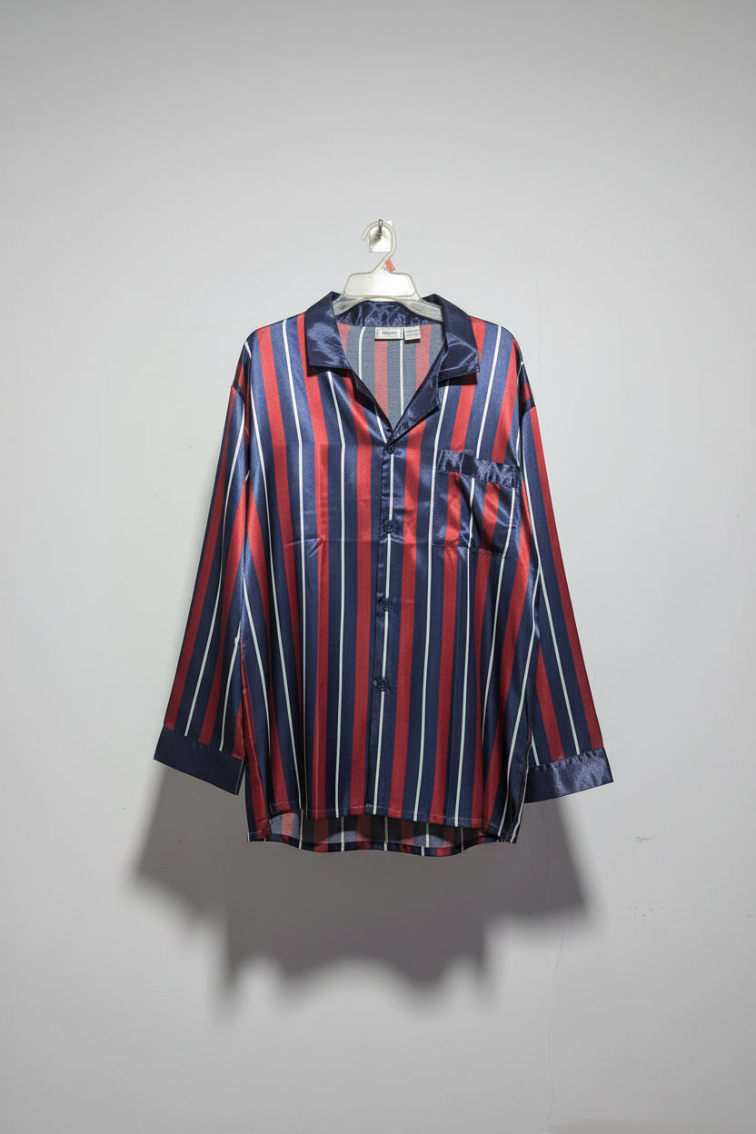 Striped shirt and pants hanging on a rack against a white wall.