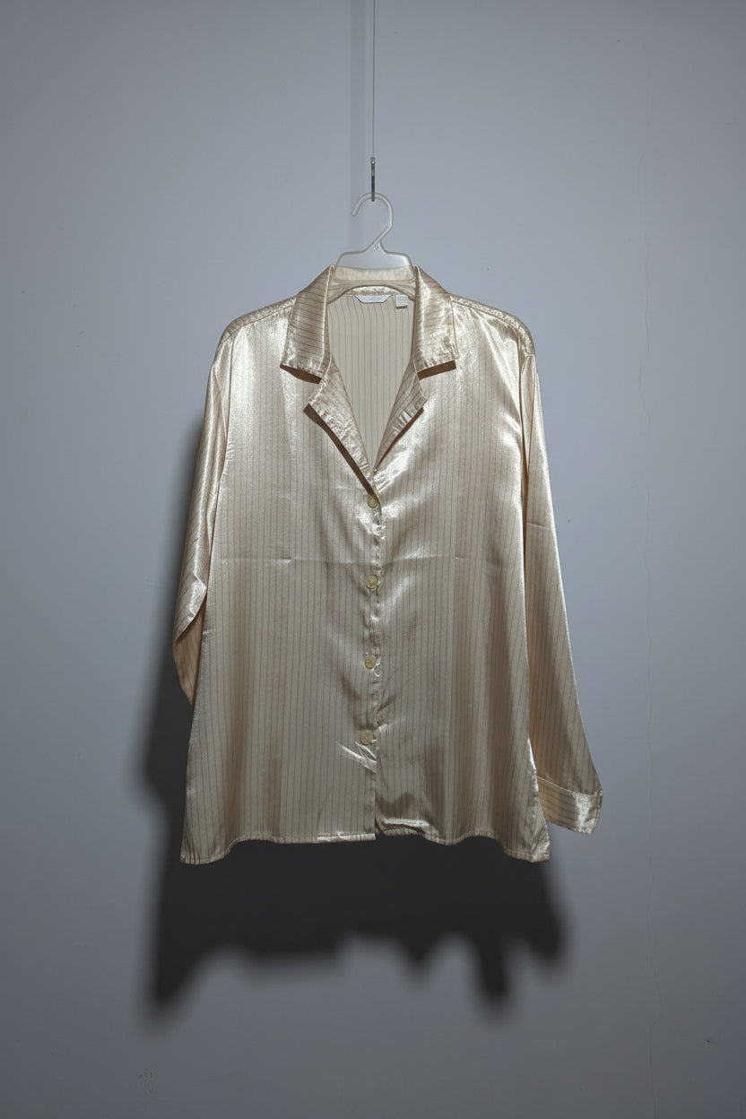 Light-colored satin jacket on a hanger against a plain background