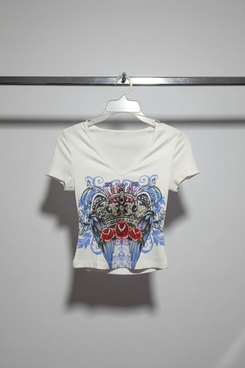 White t-shirt with a graphic design of roses and skulls on a hanger.