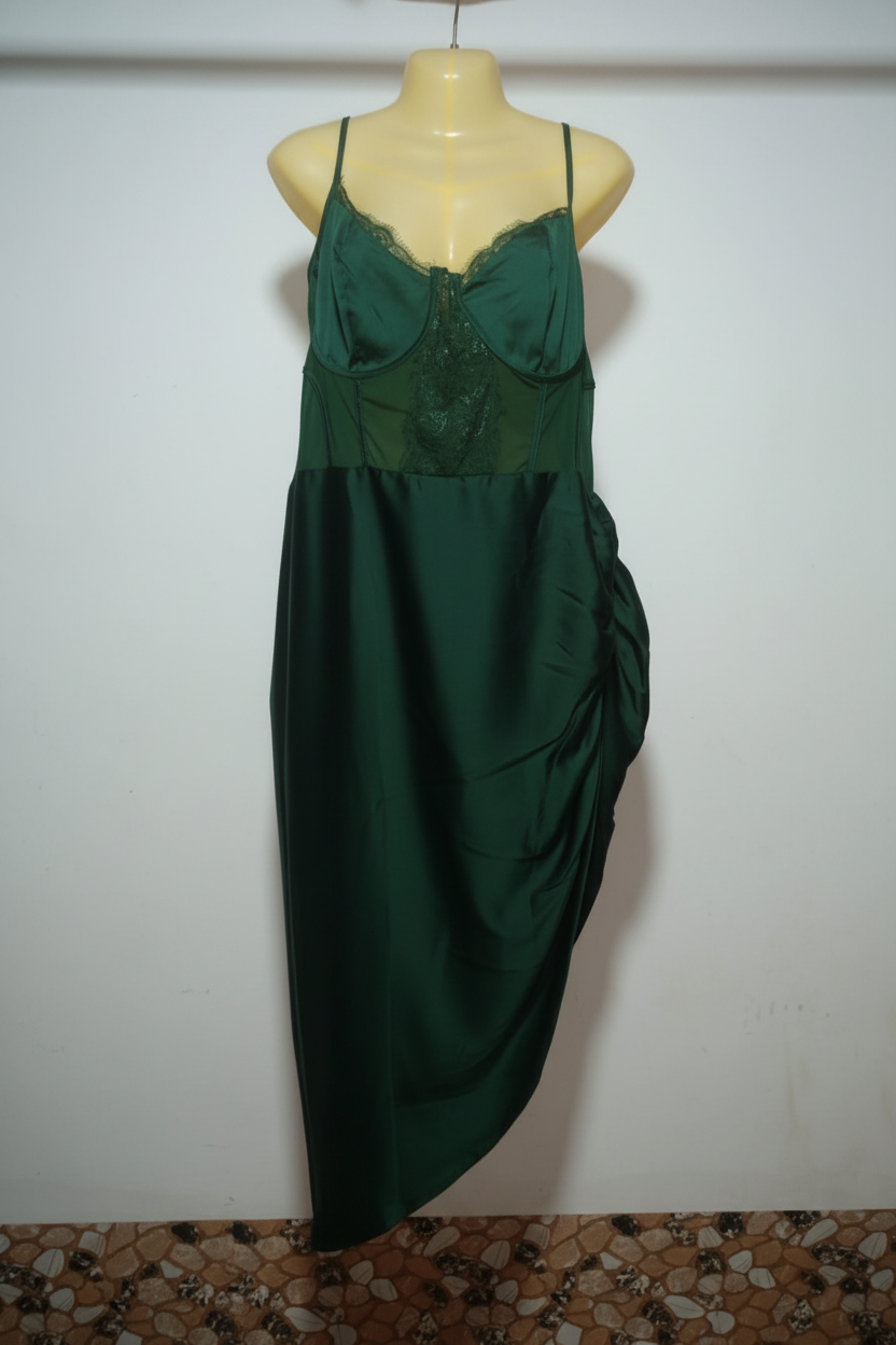 Green evening gown on a mannequin against a white wall.