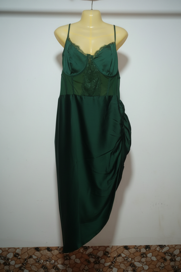 Green evening gown on a mannequin against a white wall.