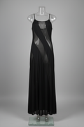 Black dress on a mannequin against a white wall.