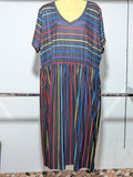 Colorful striped dress on a mannequin against a white wall.