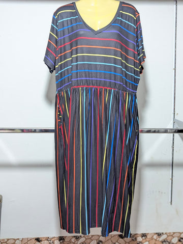 Colorful striped dress on a mannequin against a white wall.