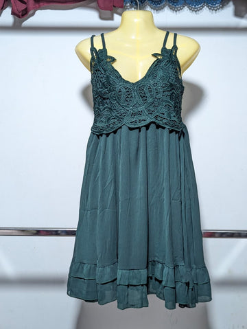 Teal dress with lace detailing on a mannequin against a white background