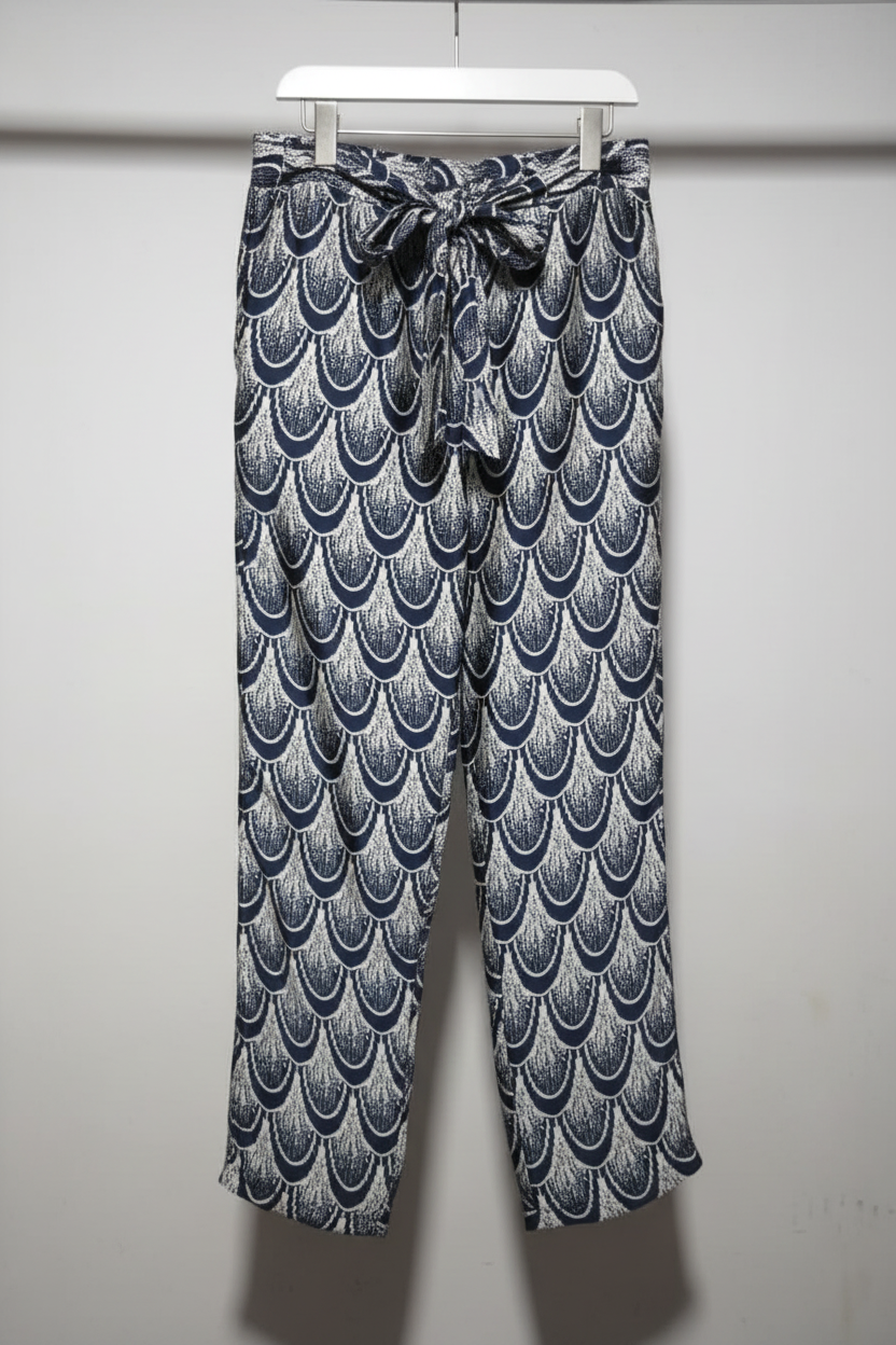 Patterned pants hanging on a rack against a white wall
