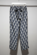 Patterned pants hanging on a rack against a white wall