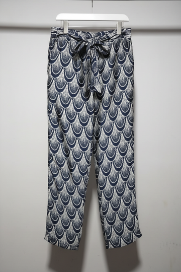 Patterned pants hanging on a rack against a white wall