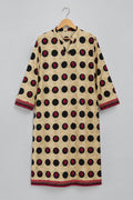 A beige tunic-style top with black and red polka dots, hanging on a hanger against a white wardrobe door.