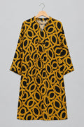 A black and yellow patterned tunic top with a chain-link design, hanging on a metal hanger against a white wardrobe door, with a hand holding the hem on the left.