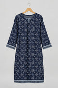 A long-sleeve tunic dress with a dark navy blue and white geometric pattern, hanging on a metal hanger against a white wardrobe door.