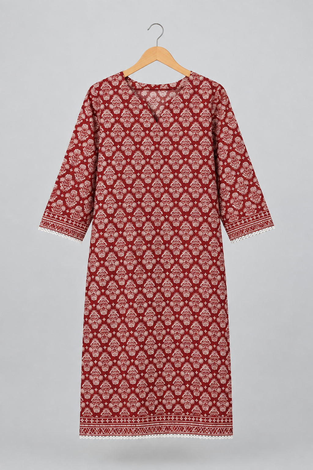 A red and white patterned cotton tunic dress with three-quarter sleeves hanging on a metal hanger against a white wardrobe door.
