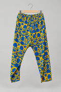 Blue and yellow patterned pants hanging on a metal hanger against a white wardrobe door.